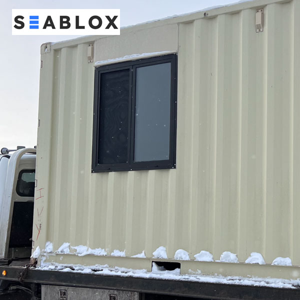 Shipping container window installed in container wall